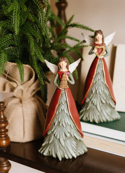Statuina natalizia dell'angelo custode Magic Noel di Nuvole di Stoffa in resina, con grandi ali dorate intagliate, abito verde a forma di albero d'abete innevato e un cuore oro tra le mani, Tutto Chic.