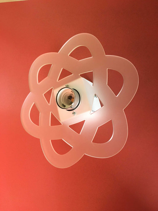 Applique in metacrilato bianco satinato con supporto in metallo verniciato bianco e particolari in metallo cromato. Si può applicare qualsiasi lampadina con attacco filettato E 27 (non inclusa). Dimensioni: cm 26 x 26 x 8,5. In negozio e online su tuttochic.live