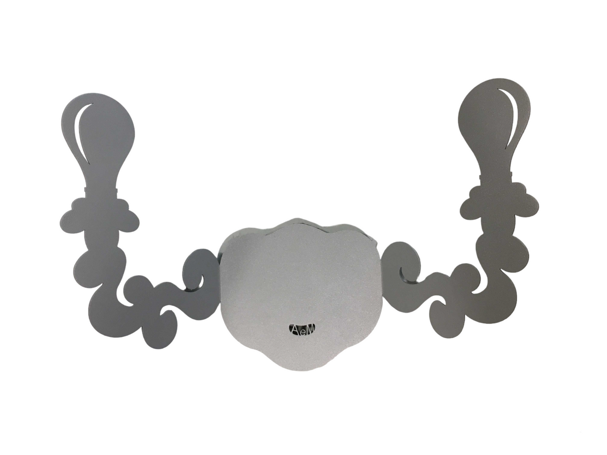 Appendiabiti da parete in metallo che raffigura un applique con due ganci laterali a forma di lumetti. Dimensione: 35 x 24 H (massimo ingombro)Materiale: ferro verniciato a polvere epossidica di colore grigio alluminio. In negozio e online su tuttochic.live