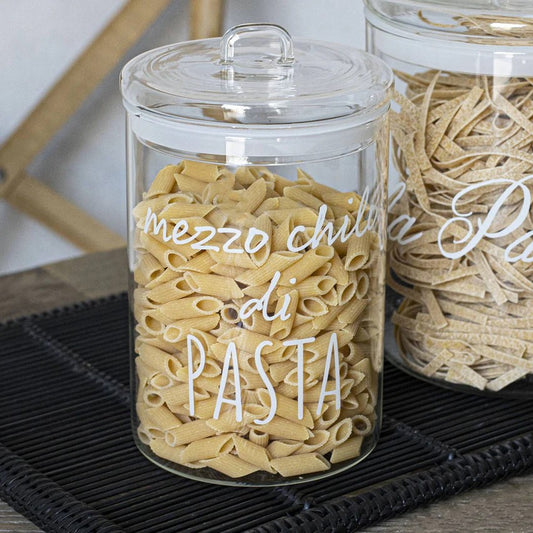 Il barattolo di vetro borosilicato trasparente, con la scritta "mezzo chilo di pasta" e la guarnizione ermetica, è ideale per conservare i tuoi alimenti preferiti in modo sicuro e stiloso. Dimensioni: ø 12 x h 20 cm. In negozio e online su tuttochic.live