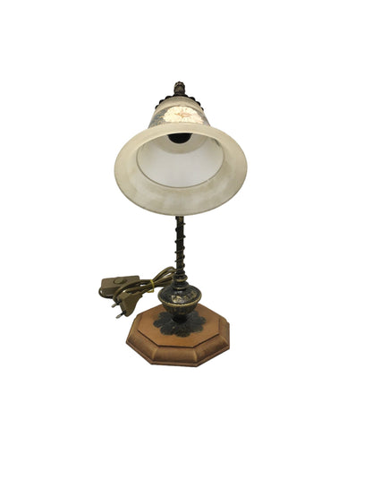 Lampada da tavolo in stile classico con braccetto in metallo di colore bronzo e oro, base in legno di forma ottagonale e coppa in vetro sabbiato decorato a mano, funziona con una lampadina attacco piccolo E14 (non inclusa). Dimensioni: cm 22 x 33 h - base cm 14 x 14. In negozio e online su tuttochic.live