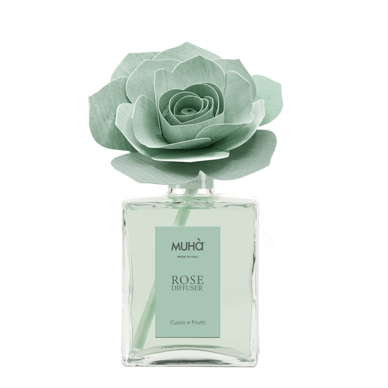 Profumatore d'ambiente Muhà Rose Diffuser Cuoio e Frutti in flacone grande squadrato di vetro trasparente con essenza verde chiaro, etichetta verticale verde salvia e diffusore artigianale a forma di rosa in legno color verde menta pallido, Tutto Chic.