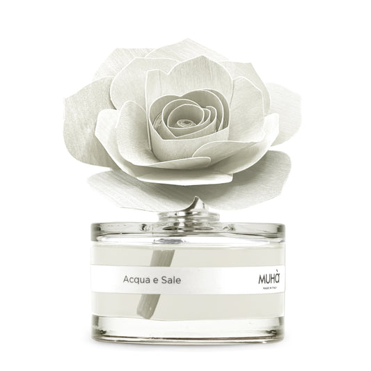 Profumatore d'ambiente Muhà Rosa Diffuser Acqua e Sale in boccetta di vetro trasparente con essenza cristallina, etichetta bianca e diffusore artigianale a forma di rosa in legno bianco avorio, Tutto Chic.