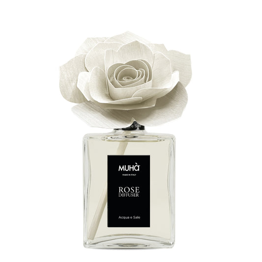 Profumatore d'ambiente Muhà Rose Diffuser Acqua e Sale in flacone grande squadrato di vetro trasparente con essenza limpida, etichetta verticale nera e diffusore artigianale a forma di rosa in legno bianco panna, Tutto Chic.