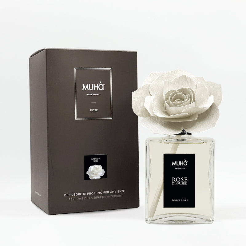 Profumatore d'ambiente Muhà Rose Diffuser Acqua e Sale in flacone grande squadrato di vetro trasparente con essenza limpida, etichetta verticale nera e diffusore artigianale a forma di rosa in legno bianco panna, Tutto Chic.