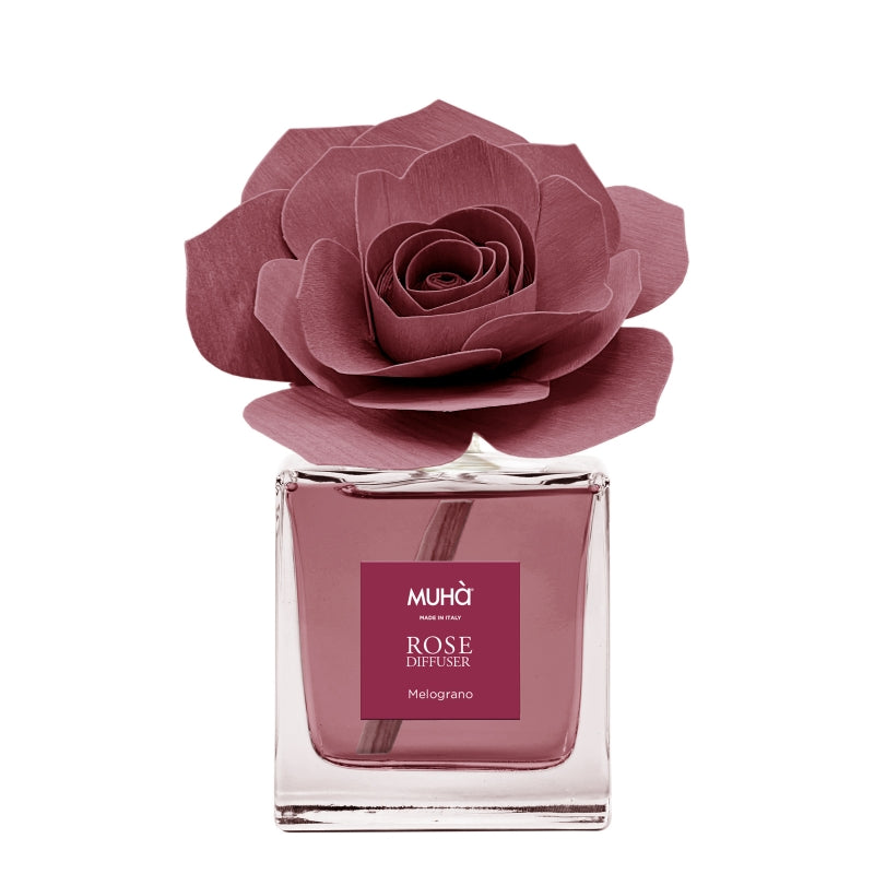 rofumatore d'ambiente Muhà Rose Diffuser Melograno in flacone squadrato di vetro trasparente con essenza fruttata, etichetta quadrata bordeaux e diffusore artigianale a forma di rosa in legno rosso melograno, Tutto Chic.