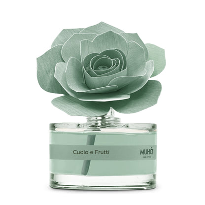 Profumatore d'ambiente Muhà Rosa Diffuser Cuoio e Frutti in boccetta di vetro trasparente con essenza verde acqua e diffusore artigianale a forma di rosa in legno verde salvia, Tutto Chic.