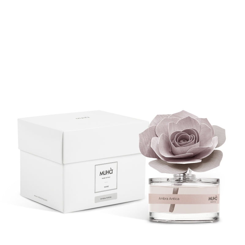 Profumatore d'ambiente Muhà Rosa Diffuser Ambra Antica in boccetta di vetro trasparente con etichetta cipria e diffusore artigianale a forma di rosa in legno rosa malva, Tutto Chic.