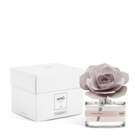 Profumatore d'ambiente Muhà Rosa Diffuser Ambra Antica in boccetta di vetro trasparente con etichetta cipria e diffusore artigianale a forma di rosa in legno rosa malva, Tutto Chic.