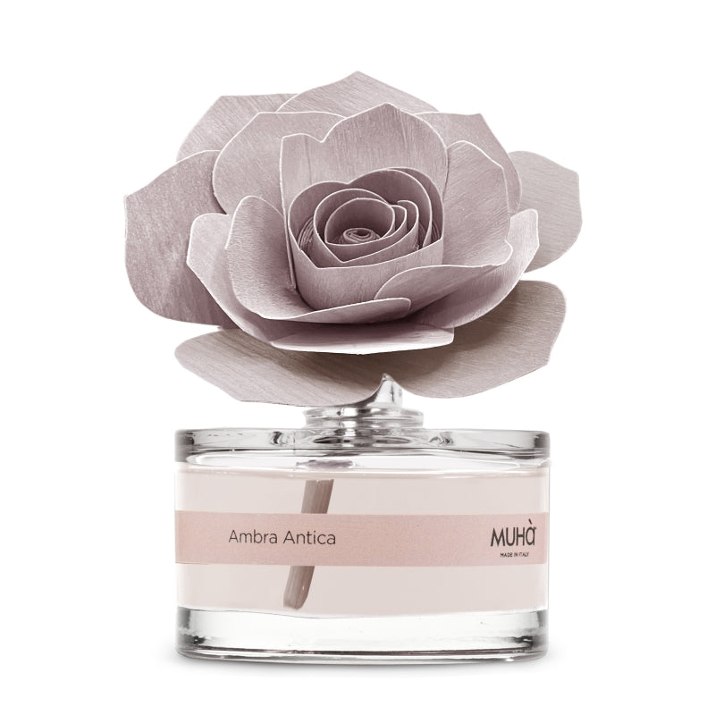 Profumatore d'ambiente Muhà Rosa Diffuser Ambra Antica in boccetta di vetro trasparente con etichetta cipria e diffusore artigianale a forma di rosa in legno rosa malva, Tutto Chic.