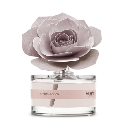 Profumatore d'ambiente Muhà Rosa Diffuser Ambra Antica in boccetta di vetro trasparente con etichetta cipria e diffusore artigianale a forma di rosa in legno rosa malva, Tutto Chic.