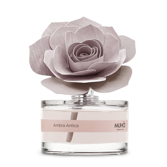 Profumatore d'ambiente Muhà Rosa Diffuser Ambra Antica in boccetta di vetro trasparente con etichetta cipria e diffusore artigianale a forma di rosa in legno rosa malva, Tutto Chic.