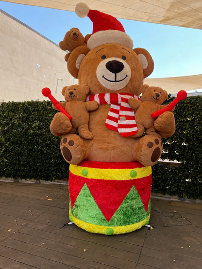 Maxi orso gonfiabile natalizio da esterno EDG alto 280 cm con rivestimento soffice effetto peluche, seduto su un tamburo festivo con orsetti piccoli e luci LED.