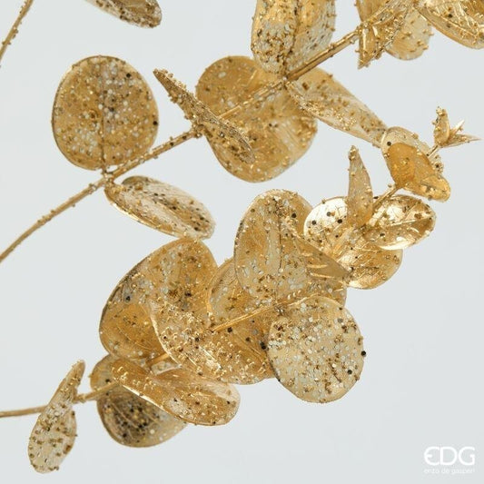 Inquadratura ravvicinata delle foglie rotonde del ramo di eucalipto oro EDG che mostra la finitura lucida con micro-glitter e paillettes brillanti.