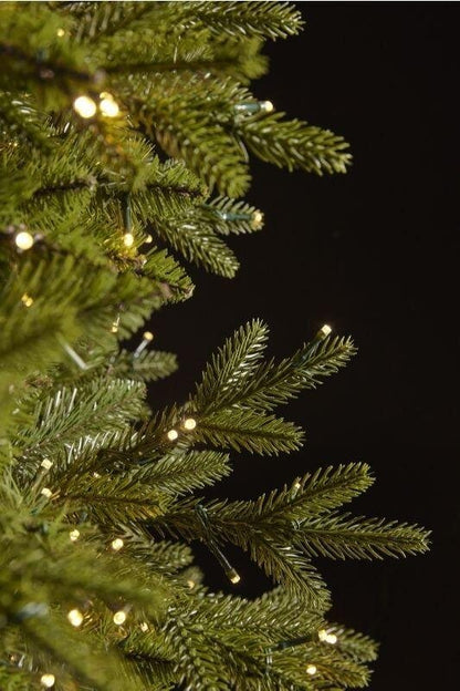 Particolare dei rami realistici in PE Real-Touch dell'albero di Natale Pino Cristallo EDG da 180 cm con mini luci LED calde dimmerabili integrate tra gli aghi.