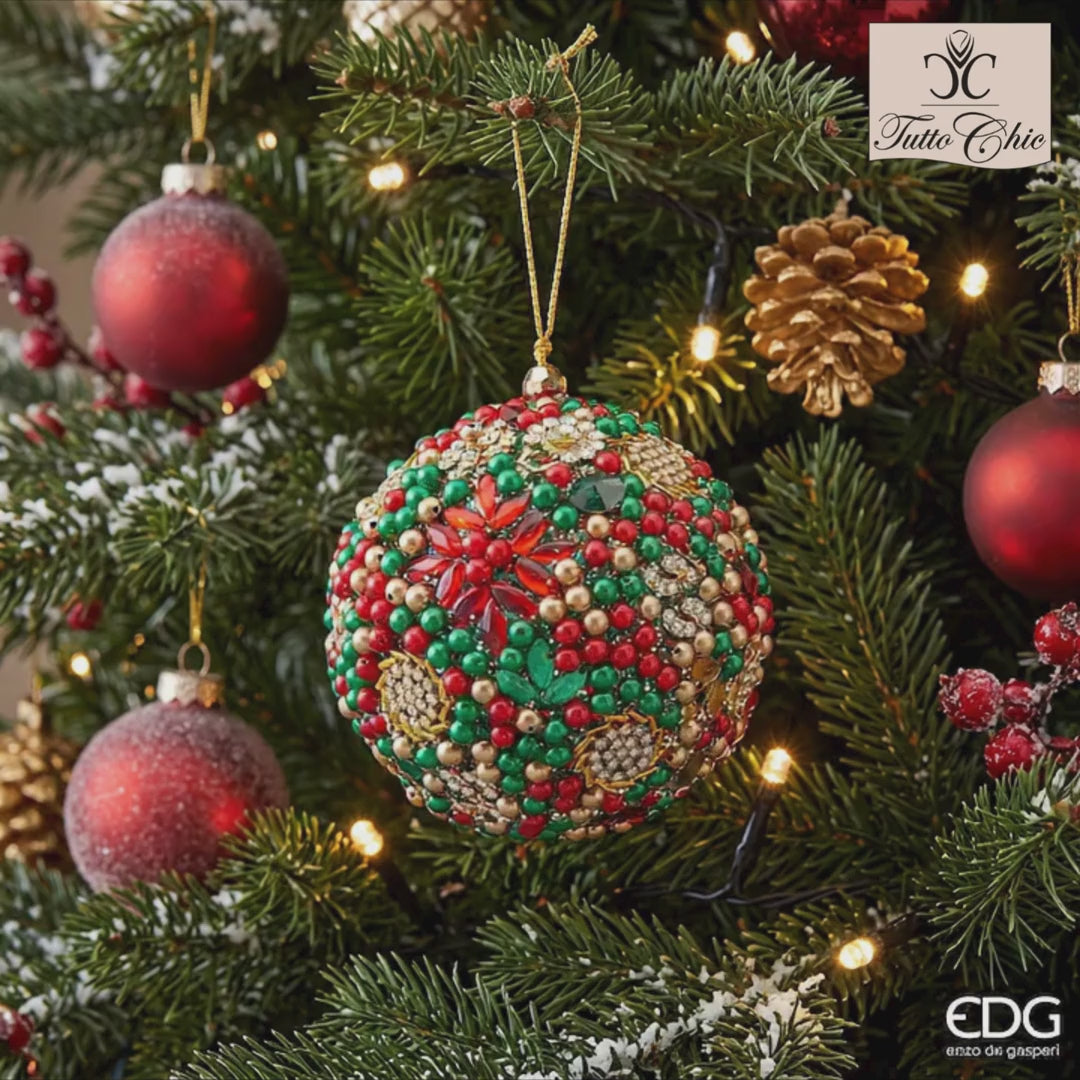 Palla di Natale gioiello della linea Mille Perle firmata EDG Enzo De Gasperi, interamente ricoperta di strass, perle verdi, rosse e castoni dorati, completa di cordino da appendere.