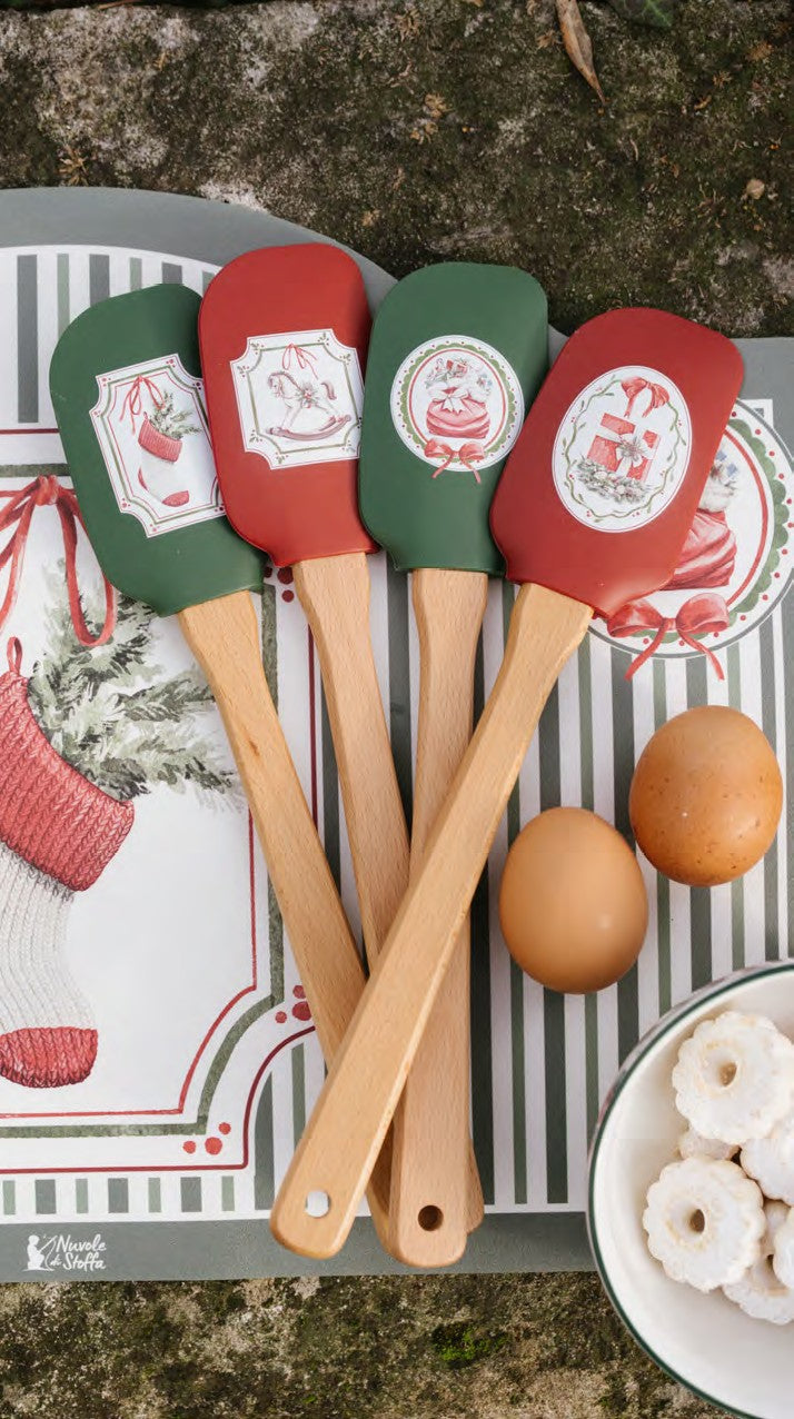 Set regalo natalizio da pasticceria Magic Noel di Nuvole di Stoffa composto da una spatola leccapentole in silicone rosso con manico in legno naturale e uno stampino tagliabiscotti in acciaio a forma di soldatino schiaccianoci con fiocco a quadri, Tutto Chic.