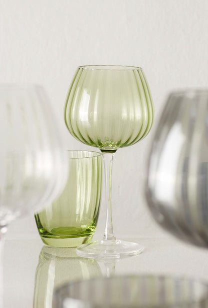 Rendete unica ogni occasione con il set di calici trasparenti della collezione Prismia di Rose & Tulipani. Realizzati in pregiato vetro soffiato e arricchiti da un delicato colore verde trasparente. Capacità: 460 ml - Dimensioni: cm 10 x 20 h. In negozio e online su tuttochic.live 