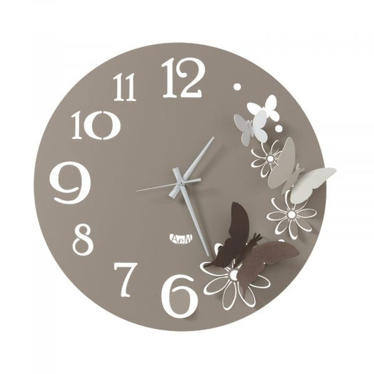 Orologio da parete in metallo di colore fango con fiori e farfalle di colore bronzo, avorio e bianco, quadrante con numeri arabi e dallo stile minimale. E' abbellito da quattro farfalline che svolazzano fra i petali di fiori intagliati nel ferro. Dimensione: diametro 45 cm. In negozio e online su tuttochic.live