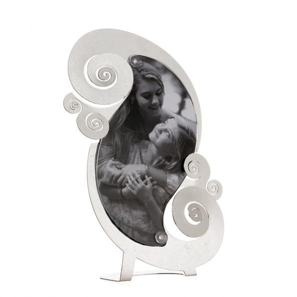 Porta foto elegante e moderno da tavolo in metallo lavorato e colorato con foglia d'argento, perfetto per incorniciare i momenti più importanti. Dimensione: 19×30 (foto14 x 23 h) L’articolo è fornito di plexiglass trasparente sagomato. In negozio e online su tuttochic.live