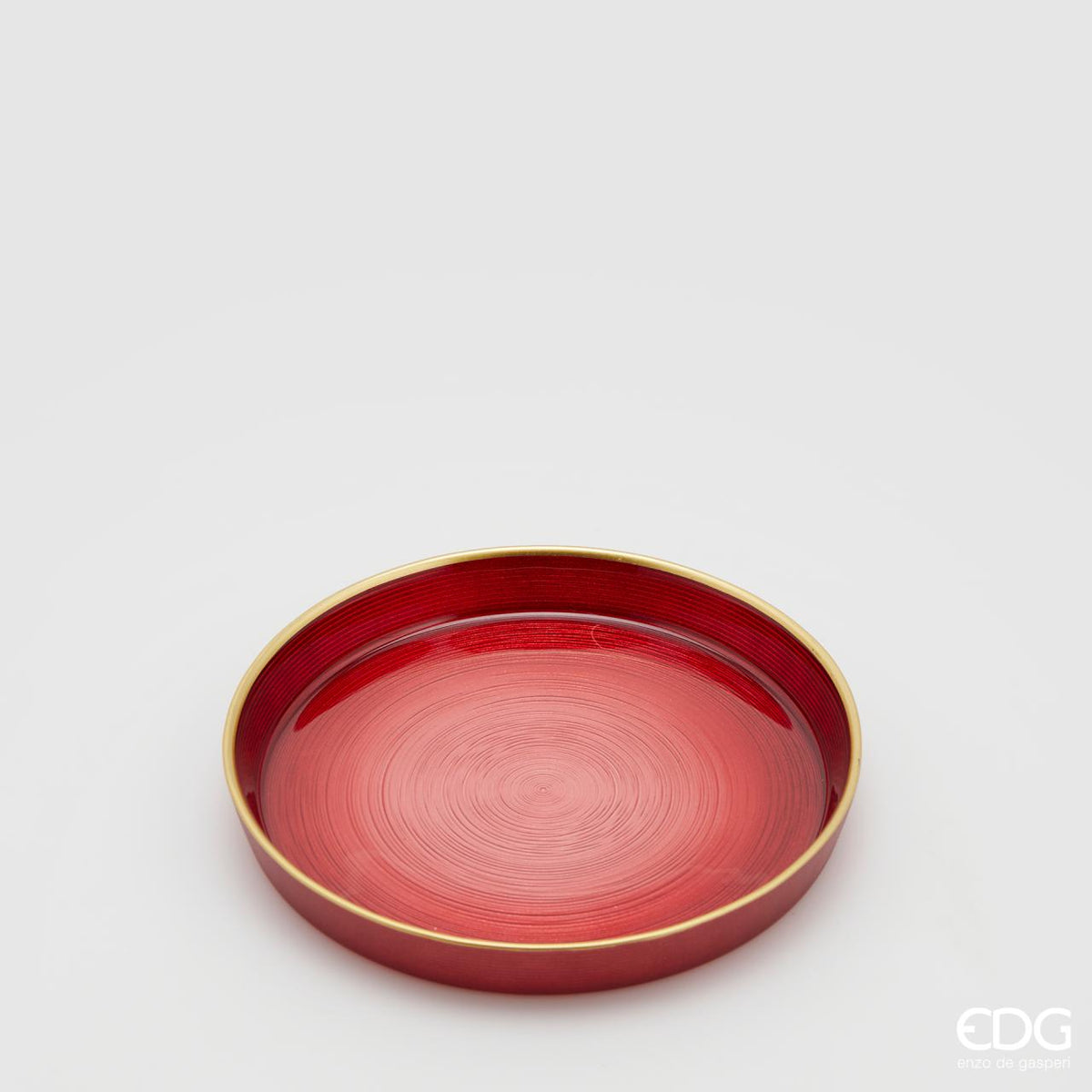 Piattino in vetro di colore rosso sfumato e bordo rialzato color oro. Ideale come base per candele o decorazioni varie. Dimensioni: diametro cm 16, altezza cm 2. In negozio e online su tuttochic.live