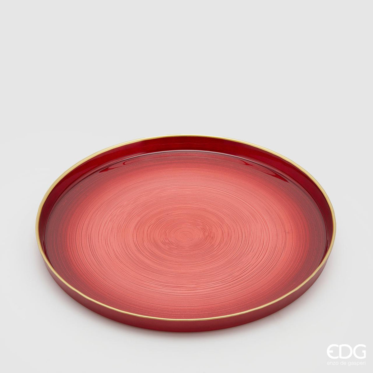 Piattino in vetro di colore rosso sfumato e bordo rialzato color oro. Ideale come base per candele o decorazioni varie. Dimensioni: diametro cm 32, altezza cm 3. In negozio e online su tuttochic.live