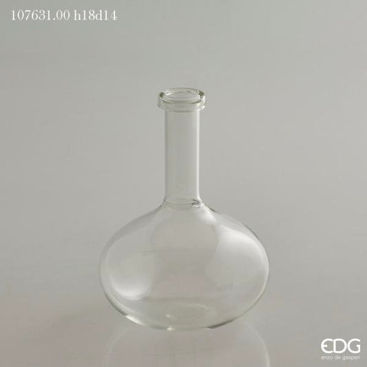 Vaso ampolla a forma di bottiglia in vetro trasparente. Ideale come vaso monofiore o ampolla per profumi ambiente. Dimensioni: cm ø 14 x h 18 (diametro bocca cm 3). In negozio e online su tuttochic.live