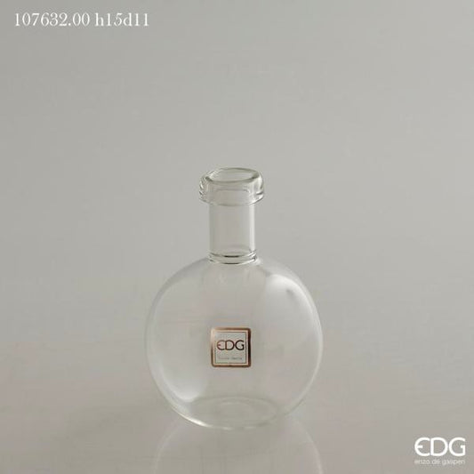 Vaso ampolla a forma di bottiglia in vetro trasparente. Ideale come vaso monofiore o ampolla per profumi ambiente. Dimensioni: cm ø 11 x h 15 (diametro bocca cm 3). In negozio e online su tuttochic.live