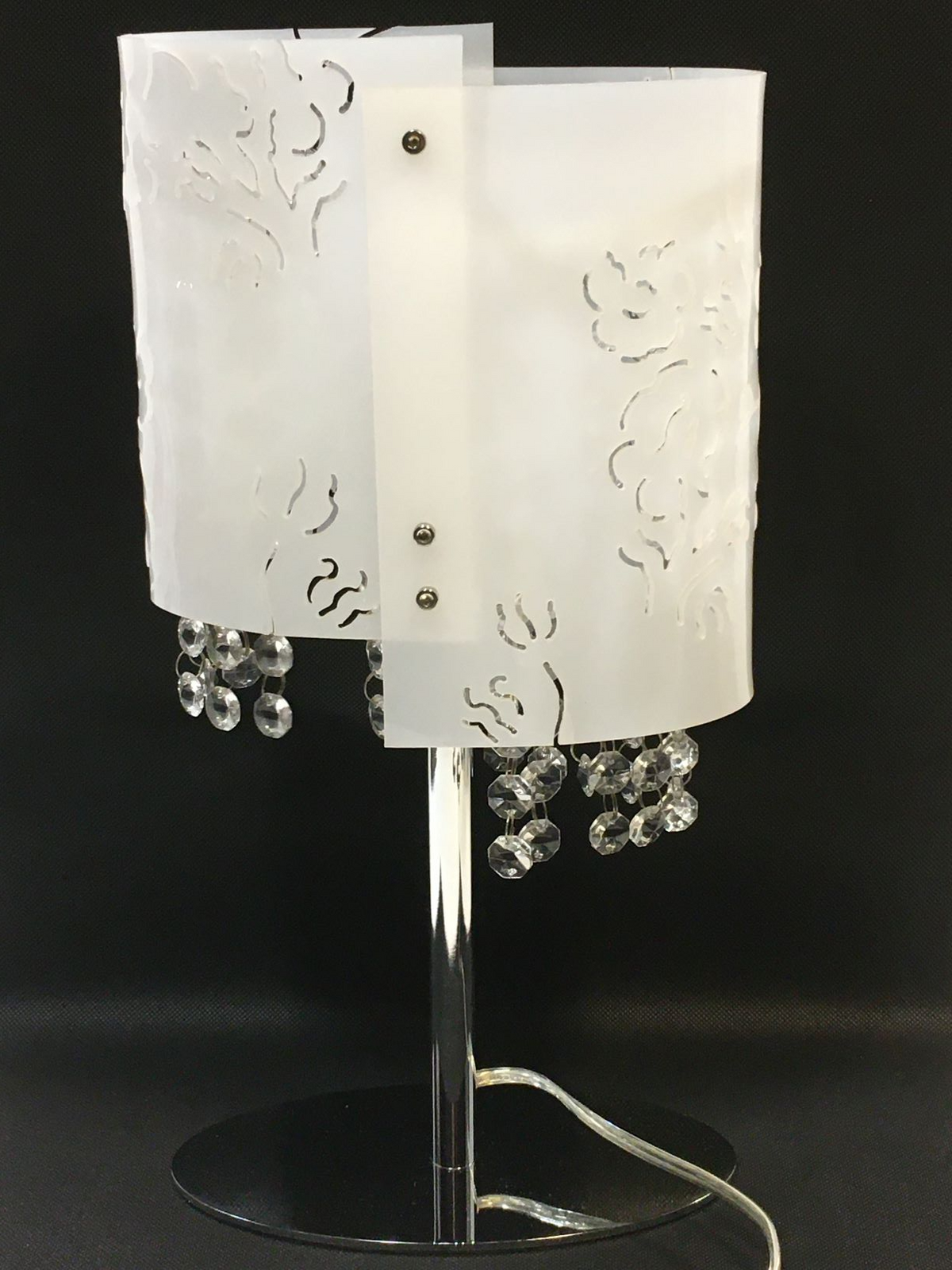 Lampada da tavolo ovale in metallo e plastica traforata decorata con strass in vetro. Dimensioni: cm 20 x 10 x 39,5 h Funzionamento a corrente con lampadina -attacco E14- . In negozio e online su tuttochic.live