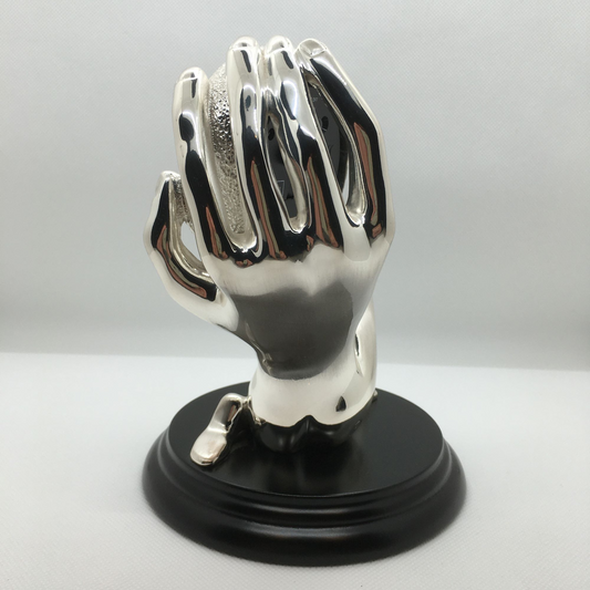 Scultura corpo-mano con orologio e sveglia in bagno galvanico in argento. Dimensioni: cm 15 x 17 h. In negozio e online su tuttochic.live 