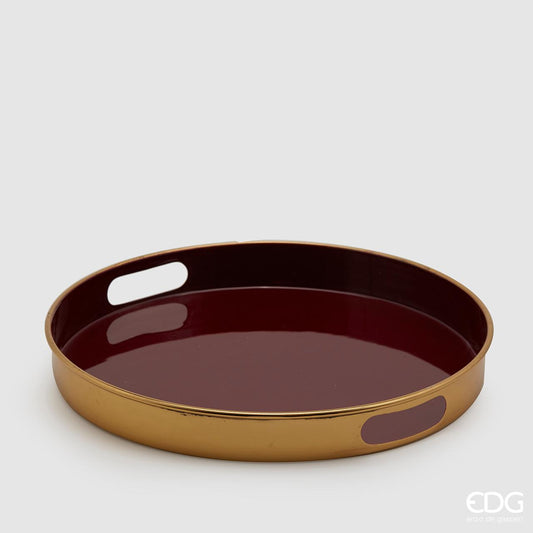Vassoio tondo in metallo color oro con piano d'appoggio smaltato di colore bordò. Dimensioni: diametro cm 37, altezza cm 5,5. In negozio e online su tuttochic.live