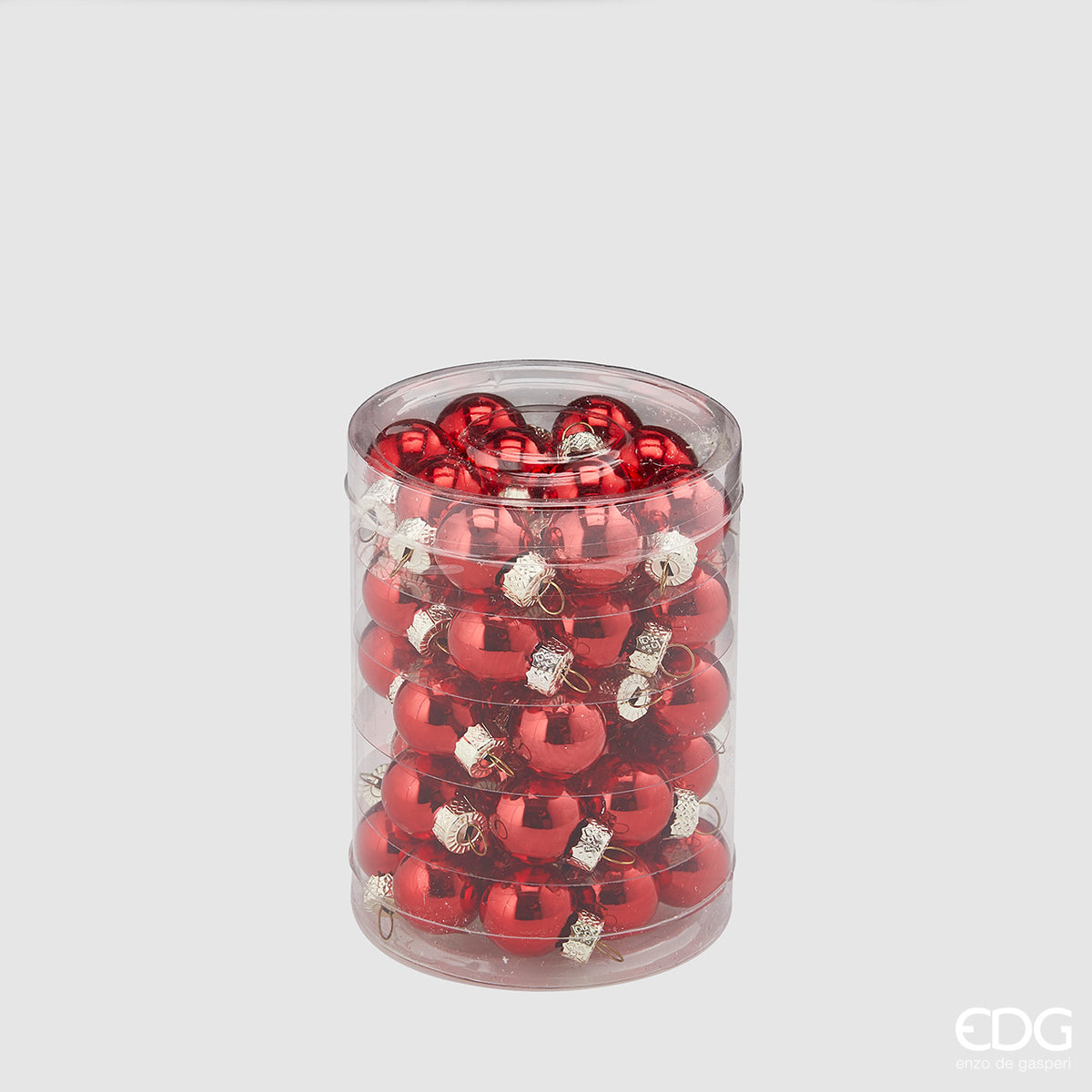 Confezione cilindrica trasparente contenente 50 mini palline di Natale in vetro soffiato color rosso lucido specchiato, diametro 2 cm, firmate EDG Enzo De Gasperi.