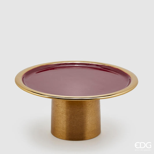 Alzata tonda in metallo color oro con piano smaltato di colore bordò. Dimensioni: cm diametro cm 29, altezza cm 14. In negozio e online su tuttochic.live