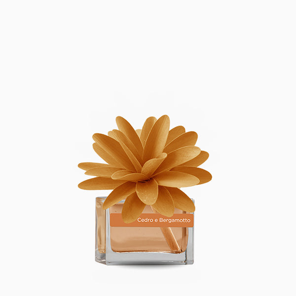 Profumatore d'ambiente con fiore in legno colorato, bottiglia in vetro rettangolare con 30 ml di fragranza. In negozio e online su tuttochic.live