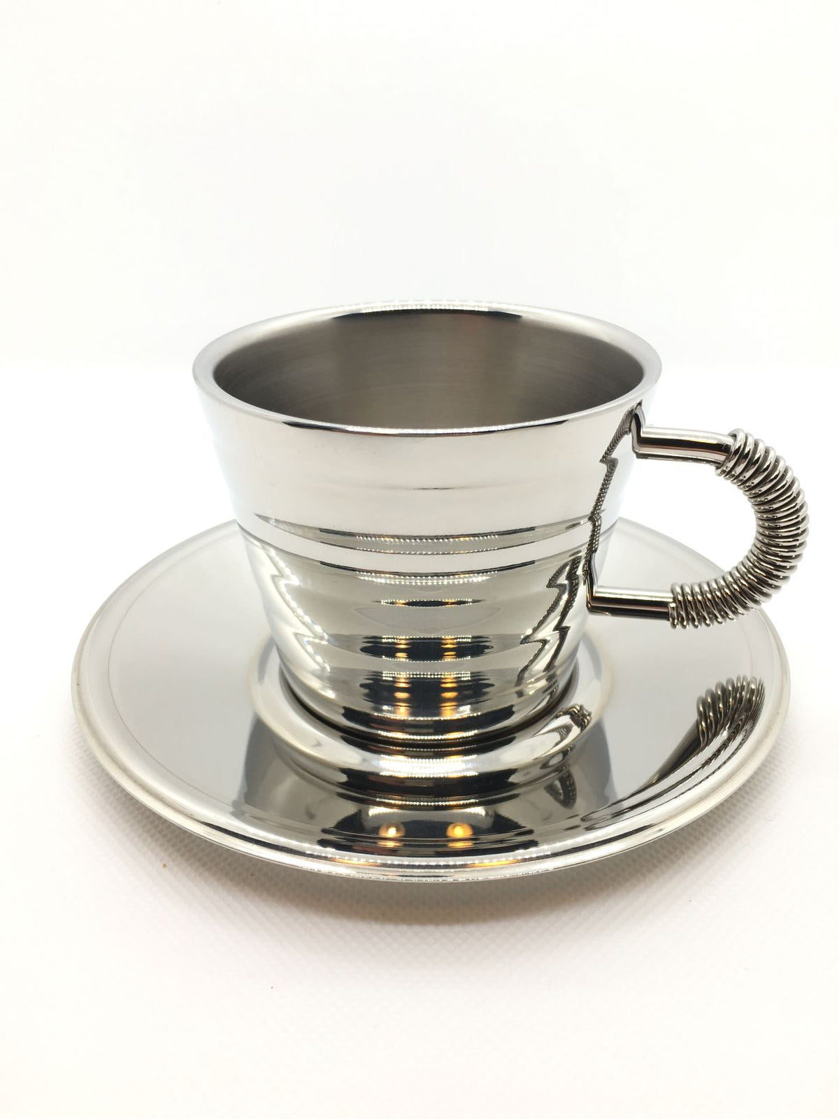 Tazza da cappuccino con piattino in acciaio inossidabile 18/10, realizzata con una doppia parete termica per mantenere la bevanda calda senza scottarsi le labbra. Dimensioni: cm 6,5 h, diametro cm 14 Capacità: 20 cl.