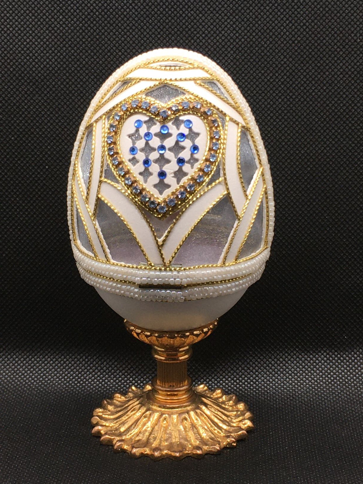 Vero uovo d'oca lavorato e decorato di colore bianco con applicazioni di strass, perline e cordoncino dorato, apribile porta gioie. Dimensioni: diametro interno cm 6,5 x 12,5 h esterno