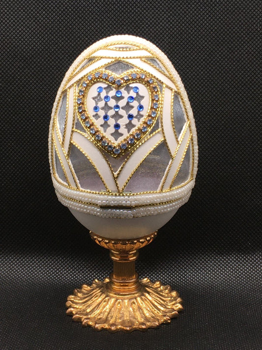 Vero uovo d'oca lavorato e decorato di colore bianco con applicazioni di strass, perline e cordoncino dorato, apribile porta gioie. Dimensioni: diametro interno cm 6,5 x 12,5 h esterno