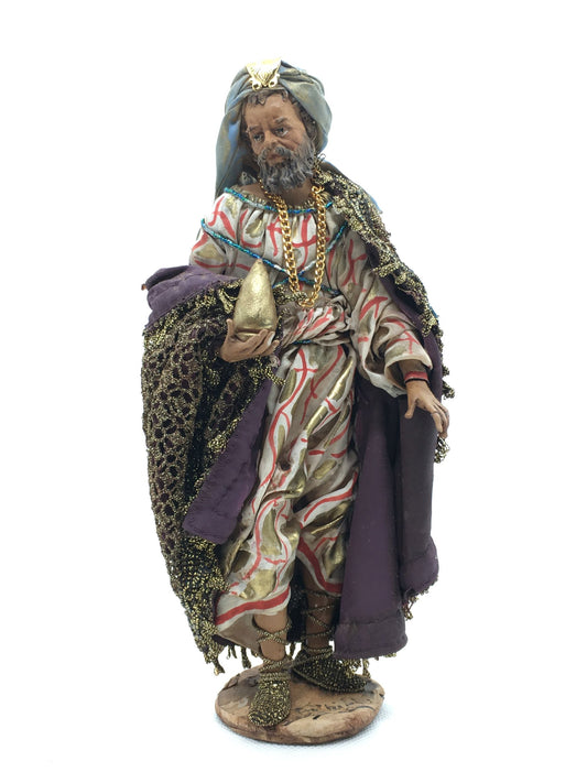Statuina del Re Magio Baldassarre per presepe di Angela Tripi, alta 20 cm, in terracotta e stoffa con mantello dorato, turbante azzurro e dono in mano.