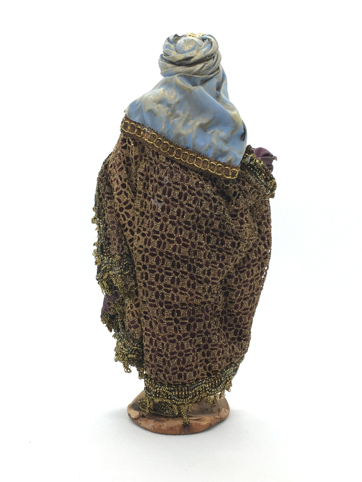Dettaglio del ricco drappeggio in tessuto e pizzo metallizzato dorato della statuina per presepe di Angela Tripi.