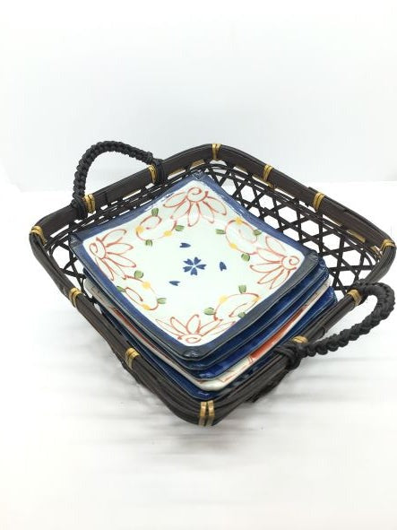 Set di 6 piattini in porcellana giapponese Saiegawari con cestino in vimini di colore nero. Dimensioni: piattino cm 14 x 14 - cestino cm 19, 5 x 25 (con manici) x 11,5 h (con manici). In negozio e online su tuttochic.live
