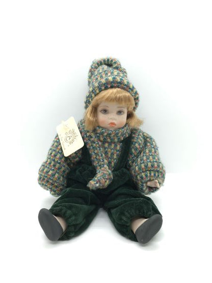 Bambola in porcellana di Capodimonte fatta e dipinta a mano, con mirabile fusione di tecnica e abilità manuale. Corpo, braccia e testa in porcellana snodabile, vestito con velluto verde scuro e cotone multicolorato. Dimensioni: cm 13 x 22 h. In negozio e online su tuttochic.live