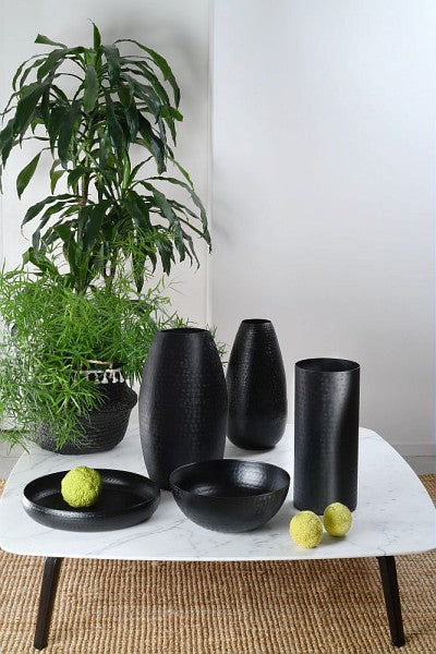 Vaso cilindrico in alluminio di colore nero. Dimensioni: cm 17 x 39H La linea atelier è realizzata in alluminio cesellato, leggero nelle forme e nel peso. In negozio e online su tuttochic.live