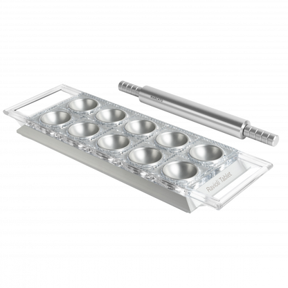 Tavoletta per Ravioli Argento Ravioli Tablet. La base è realizzata in solido alluminio anodizzato per alimenti. La superficie da taglio removibile è in policarbonato alimentare trasparente, facile da pulire e dal taglio sempre netto e preciso. Dimensioni: cm 33.8 × 12 × 2.7 h. In negozio e online su tuttochic.live