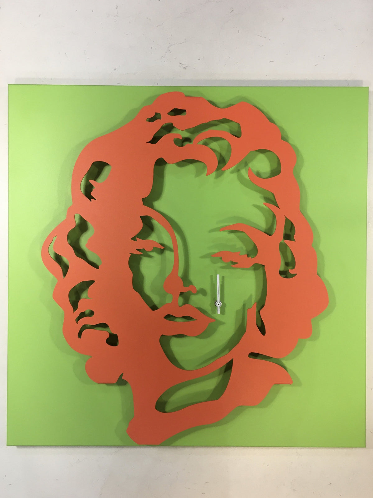 Orologio da parete in metallo di colore verde e rosso pomodoro raffigurante Marilyn Monroe. Dimensioni : cm. 59 x 59 x 6. In negozio e online su tuttochic.live