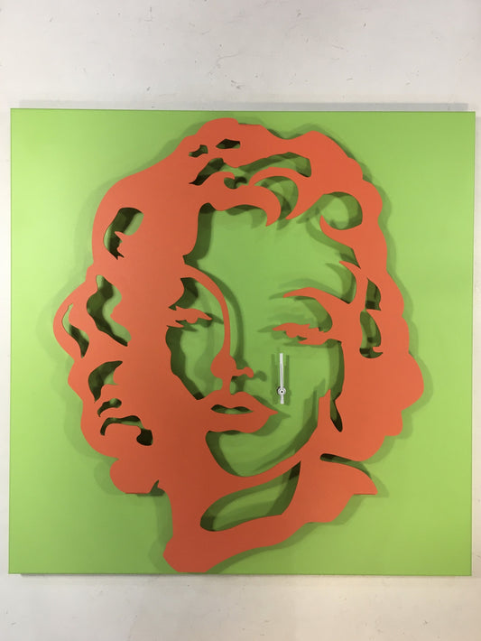 Orologio da parete in metallo di colore verde e rosso pomodoro raffigurante Marilyn Monroe. Dimensioni : cm. 59 x 59 x 6. In negozio e online su tuttochic.live