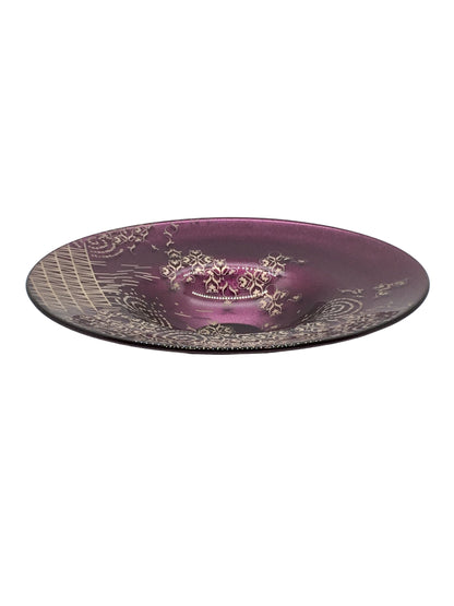 Centrotavola rotondo in vetro di colore ametista con decorazione di colore grigio/argento. Dimensioni: Ø cm 29,5 x 5,5 h. Le piccole imperfezioni che possono essere riscontrate, sono il segno di una lavorazione artistica realizzata completamente a mano. In negozio e online su tuttochic.live