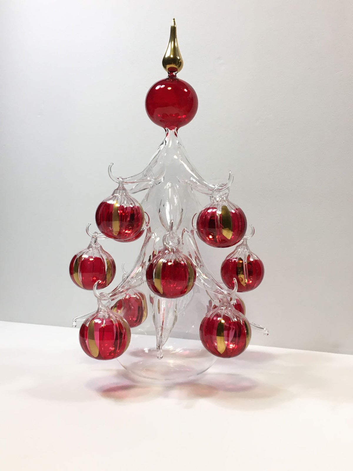 Abete in vetro soffiato con 12 palline rosso/oro, prodotto lavorato, rifinito e decorato completamente a mano. Made in Italy. Dimensioni: cm 22 x 39 h. In negozio e online su tuttochic.live