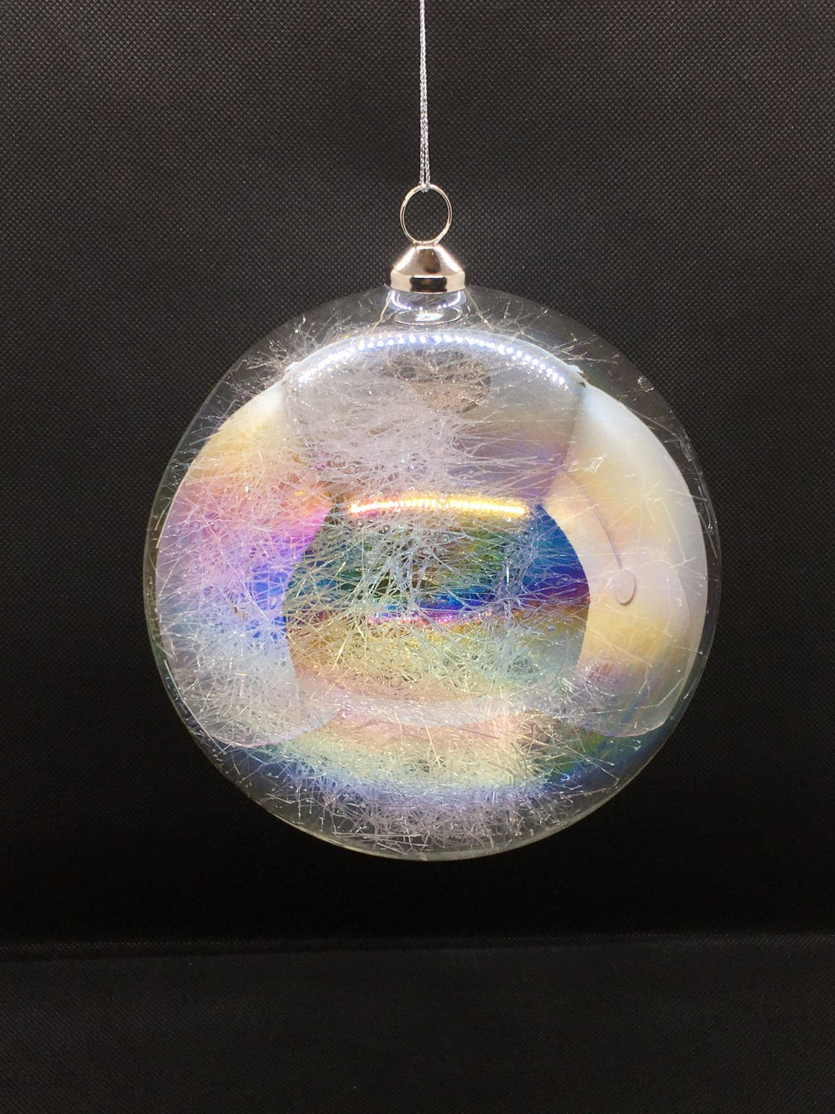 Sfera in vetro trasparente effetto Iride e decorata all'interno con fili di vetro. Decorazione per albero di Natale. Dimensione: diametro cm 15. In negozio e online su tuttochic.live