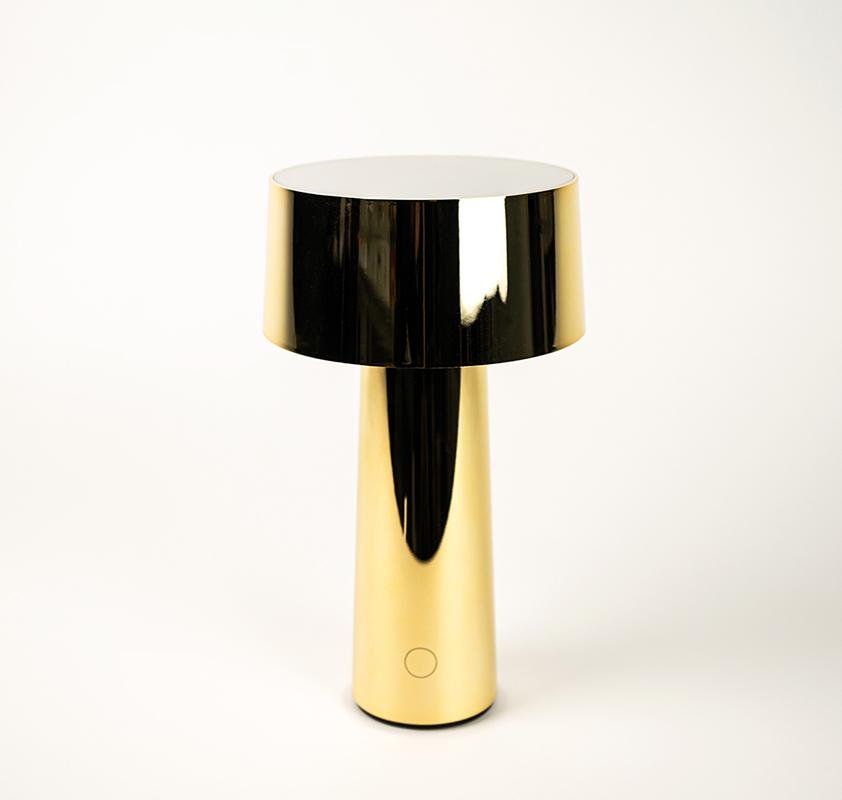 Piccola lampada color oro ricaricabile da mettere sopra un tavolo, sopra un comodino come a terra sul bordo di una stanza. Indicata anche per tavoli esterni di bar e ristoranti. Dimensioni: Ø14 x h26 cm Tipologia illuminazione: Led (Battery) 5W ricaricabile Alimentazione: 5V/1A Grado luminosità: 3000°K. tuttochic.live