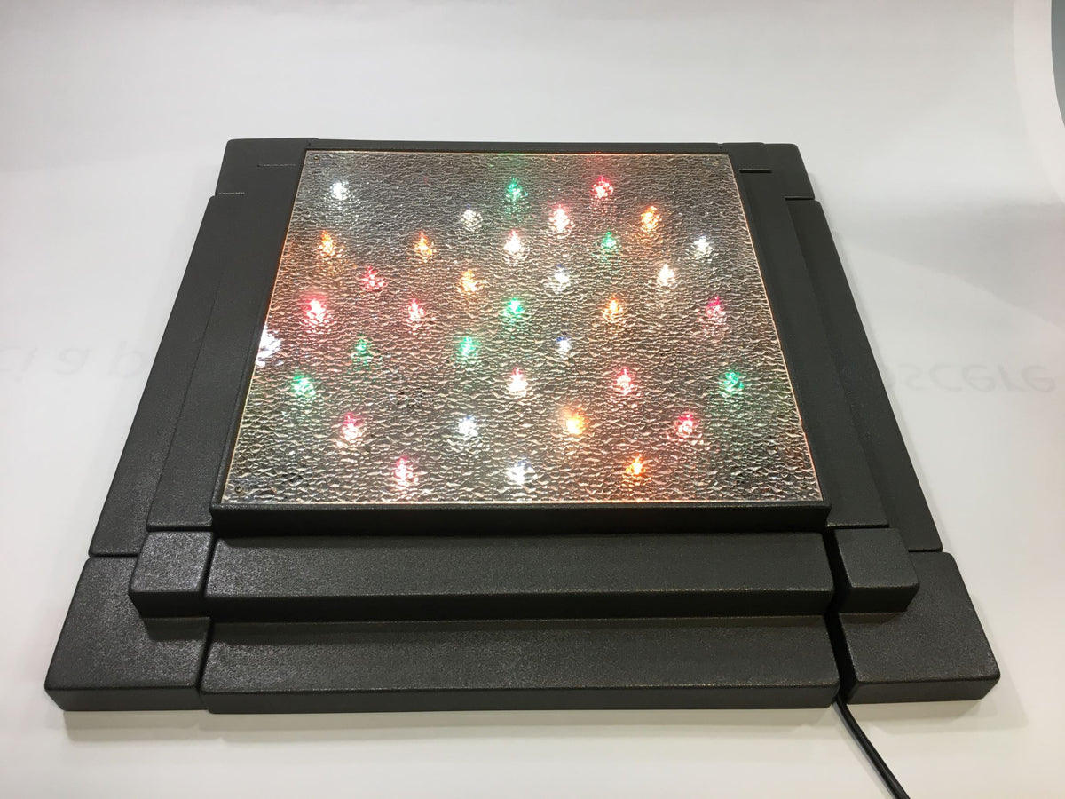 Pista da ballo illuminata (senza statuine) della linea "Ballerini in Discoteca" di Antartidee. Composta da una pista in metallo con luci colorate e coperte da un vetro, 4 gradini laterali in resina di colore antracite, 4 angolari in metallo di colore antracite. Dimensioni totali: cm 43,5 x 43,5 x 7 h